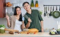 Portrait Asian happy young adult couple lover helping together, holding kitchenware, cooking in cozy home kitchen in morning, Royalty Free Stock Photo