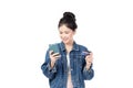 Portrait Asian happy young girl in jeans shirt smiling cheerful and showing plastic credit card while holding mobile phone Royalty Free Stock Photo