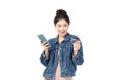 Portrait Asian happy young girl in jeans shirt smiling cheerful and showing plastic credit card while holding mobile phone Royalty Free Stock Photo