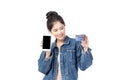 Portrait Asian happy young girl in jeans shirt smiling cheerful and showing plastic credit card while holding mobile phone Royalty Free Stock Photo