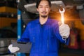 Portrait Asian Japanese male mechanic worker portrait in auto service workshop car maintenance center replace fix auto engine part Royalty Free Stock Photo