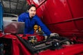 Portrait Asian Japanese male mechanic worker portrait in auto service workshop car maintenance center replace fix auto engine part Royalty Free Stock Photo