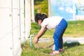 Portrait of Asian kid 5-6 years old. Little child girl was washing her hands at faucet on lawn or on playground.