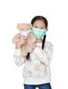 Portrait asian little child girl carry teddy bear with wearing medical protective mask together isolated on white background and Royalty Free Stock Photo