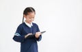 Portrait of asian little child girl in school uniform using tablet isolated on white background with copy space Royalty Free Stock Photo