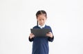 Portrait of asian little child girl in school uniform using tablet isolated on white background. Studio shot Royalty Free Stock Photo