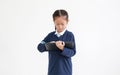 Portrait of asian little child girl in school uniform using tablet isolated on white background. Studio shot Royalty Free Stock Photo