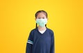 Portrait asian little child girl with wearing medical mask isolated on yellow background Royalty Free Stock Photo