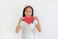 Portrait of Asian little girl child holding red heart sign on white background Royalty Free Stock Photo