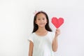 Portrait of Asian little girl child holding red heart sign on white background Royalty Free Stock Photo