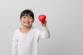 Portrait of Asian little girl child holding red heart sign on white background Royalty Free Stock Photo