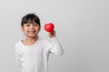 Portrait of Asian little girl child holding red heart sign on white background Royalty Free Stock Photo