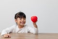 Portrait of Asian little girl child holding red heart sign on white background Royalty Free Stock Photo