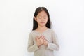 Portrait of Asian little girl closed eyes and holding hands on heart gesture of love. Kid place arms on chest isolated on white