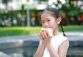 Portrait of Asian little girl eating bread with Stuffed Strawberry-filled dessert in garden outdoor Royalty Free Stock Photo