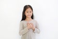 Portrait of Asian little girl holding hands on heart gesture of love. Kid place arms on chest isolated on white background