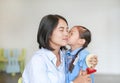 Portrait Asian little girl kissing her mom and hugging on Mother`s day in thailand. Kid Pay respect and give Thai traditional Royalty Free Stock Photo