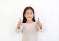 Portrait Asian little kid girl child pointing at you and looking camera isolated on blue background. Child point two index fingers Royalty Free Stock Photo