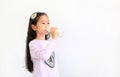 Portrait of asian little kid girl drinking milk from glass bottle isolated on white background with copy space Royalty Free Stock Photo