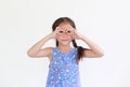 Portrait asian little kid girl with hands glasses in front of her eyes isolated on white background. Child looking through Royalty Free Stock Photo