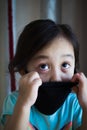 Portrait of asian Little toddler girl wearing reusable black fabric mask for protection from Coronavirus and Covid-19. Copy space Royalty Free Stock Photo