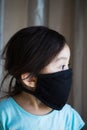 Portrait of asian Little toddler girl wearing reusable black fabric mask for protection from Coronavirus and Covid-19. Copy space Royalty Free Stock Photo