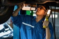 Portrait of asian male car mechanic performing car checking and maintenace service at garage and car maintenance service station Royalty Free Stock Photo