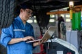 Portrait of asian male car mechanic performing car checking and maintenace service at garage and car maintenance service station Royalty Free Stock Photo