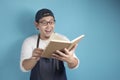 Portrait of Asian male chef reading book of recipes, finding secret recipe