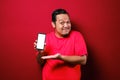 Portrait of Asian male looks happy and proud showing empty copy space smart phone Royalty Free Stock Photo