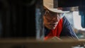 Portrait of asian male mechanic engineer working with steel drilling machine in metal work manufacturing factory Royalty Free Stock Photo