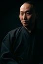 Portrait of an Asian man in a black robe on a black background Royalty Free Stock Photo