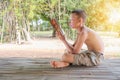 Portrait of asian man children. he is reading a book under his house and have a sunset. learning is not just about studying in the Royalty Free Stock Photo