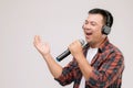 Portrait Asian man listening song or music from black headphone. Studio shot isolated on grey