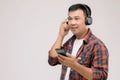 Portrait Asian man listening song or music from black headphone. Studio shot isolated on grey