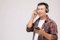 Portrait Asian man listening song or music from black headphone. Studio shot isolated on grey