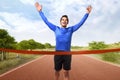 Portrait of asian man running crossing the finish line Royalty Free Stock Photo