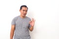 Portrait of Asian man stand happy and positive approving with a big smile and funny face expressing okay gesture isolated over Royalty Free Stock Photo