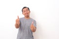 Portrait of Asian man stand happy and positive with thumbs up approving with a big smile and funny face expressing okay gesture Royalty Free Stock Photo