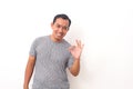 Portrait of Asian man stand happy and positive with thumbs up approving with a big smile and funny face expressing okay gesture Royalty Free Stock Photo