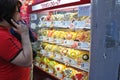 Portrait of Asian man using mobile phone and selecting the dessert from the display shelf