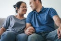 Portrait of Asian mature couple sitting in the living room. wife and husband hugging, holding hand with happiness and cheerful. Royalty Free Stock Photo