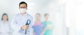 Portrait of Asian medical male Doctor wear a mask to prevent germs and standing in front of his blurred team staff in hospital Royalty Free Stock Photo