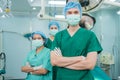 Portrait of Asian men surgeon and nurse with medical mask standing with arms crossed in operation theater at a hospital. Team of Royalty Free Stock Photo