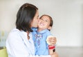 Portrait of Asian mom kissing and hugging her daughter on Mother`s day in thailand. Royalty Free Stock Photo