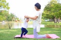 Portrait of Asian mother doing baby yoga for her son on green lawn in the nature garden outdoor Royalty Free Stock Photo