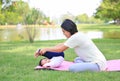 Portrait of Asian mother doing baby yoga for her son on green lawn in the nature garden outdoor Royalty Free Stock Photo