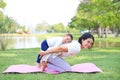 Portrait of Asian mother doing exercise for her son on green lawn in the nature garden outdoor Royalty Free Stock Photo