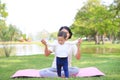 Portrait of Asian mother doing exercise for her son on green lawn in the nature garden outdoor Royalty Free Stock Photo