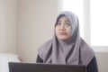 Muslim Businesswoman Working on Laptop at Home, Thinking Gesture